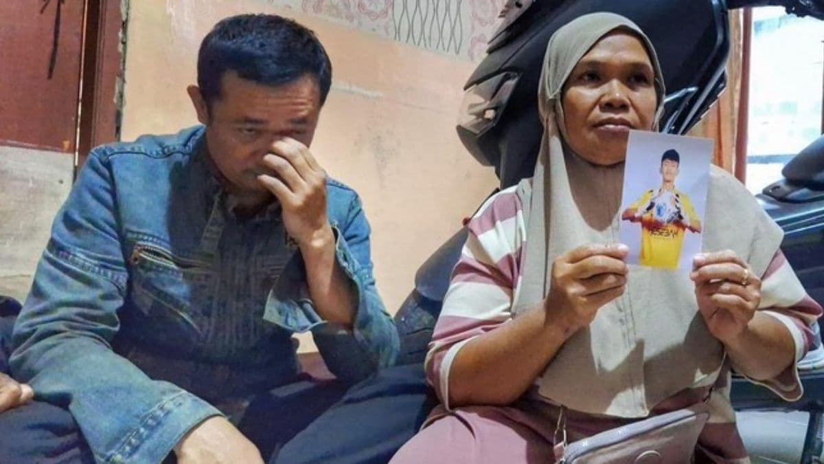 Rizki’s father, Dedi Solehudin (42), and his grandmother, Imas Siti Rohanah (52), showing a photo of Rizki.